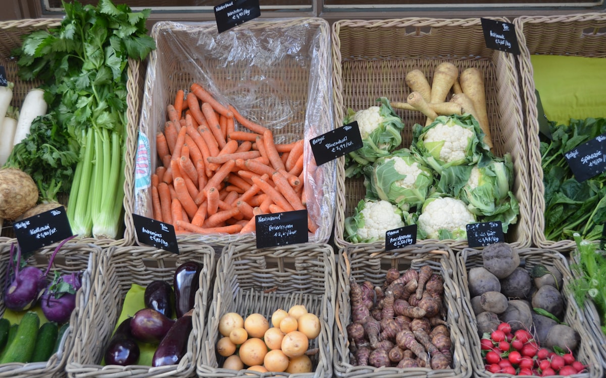 A variety of vegetables are displayed in baskets