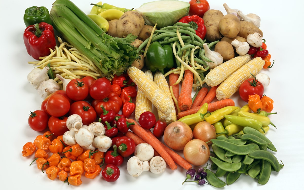 A pile of different types of vegetables on a white surface