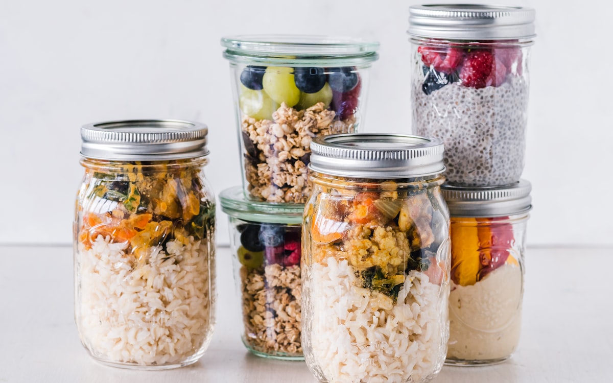 Six full clear glass jars on white surface