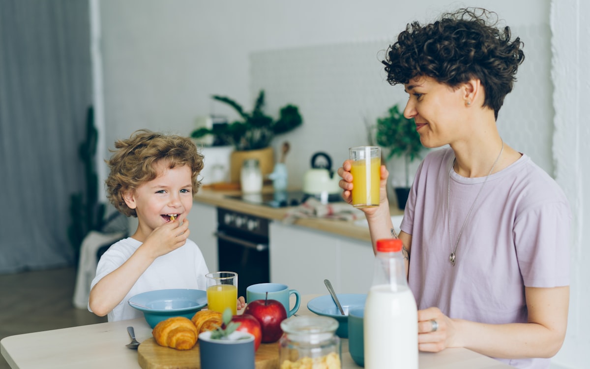 A woman and a child sitting at a kitchen table