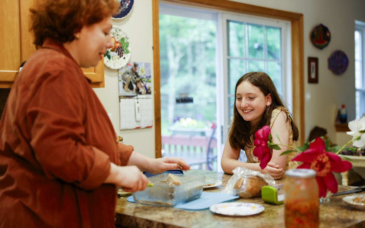 Woman preparing food with a girl watching