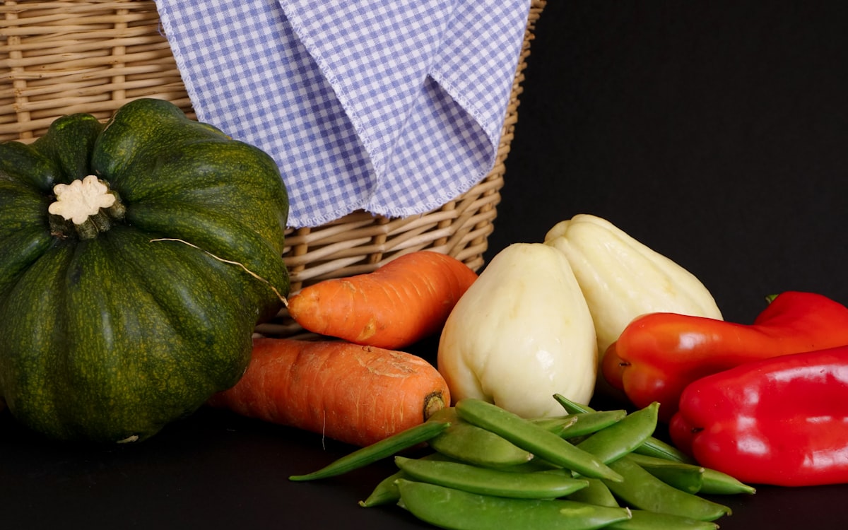 Orange and white pumpkin beside green round fruit