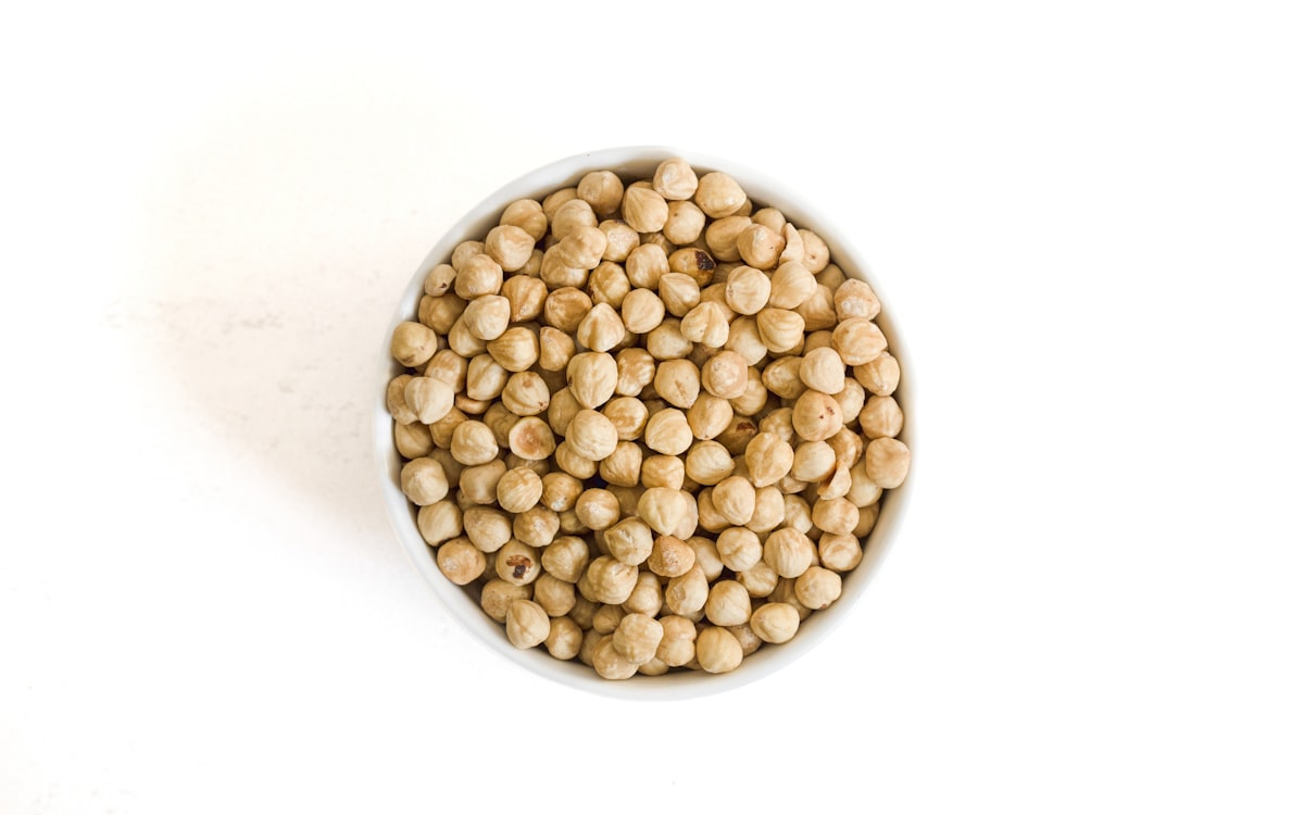 Bowl of dried chickpeas on a white background
