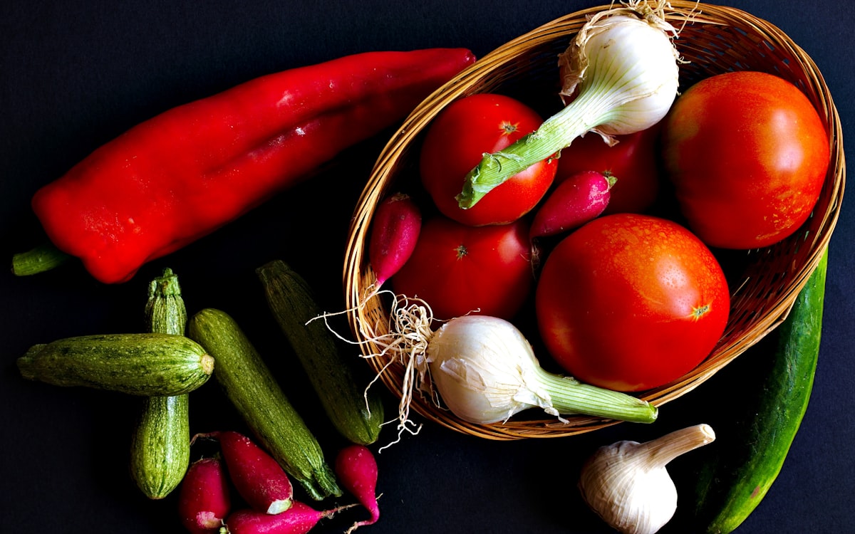 Assorted vegetables and brown wicker basket
