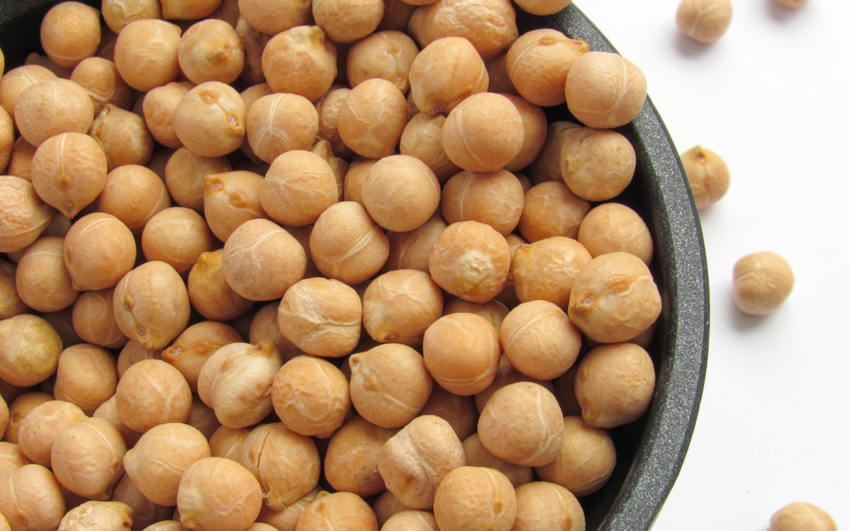 A bowl filled with chickpeas sitting on top of a table