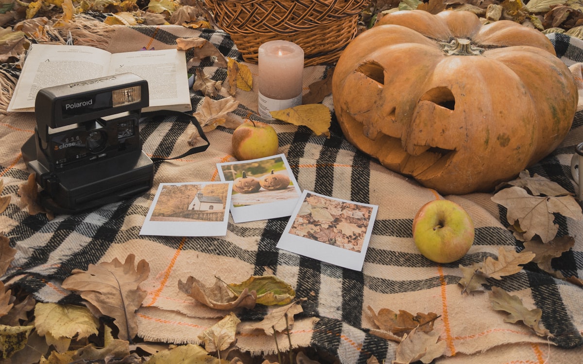 A table topped with pictures and a pumpkin